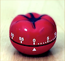 A red pomodoro on a wood surface Description automatically generated